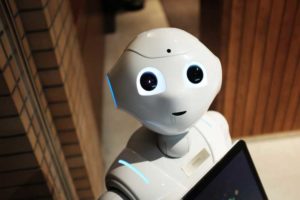 A friendly humanoid robot with glowing eyes, looking straight ahead.